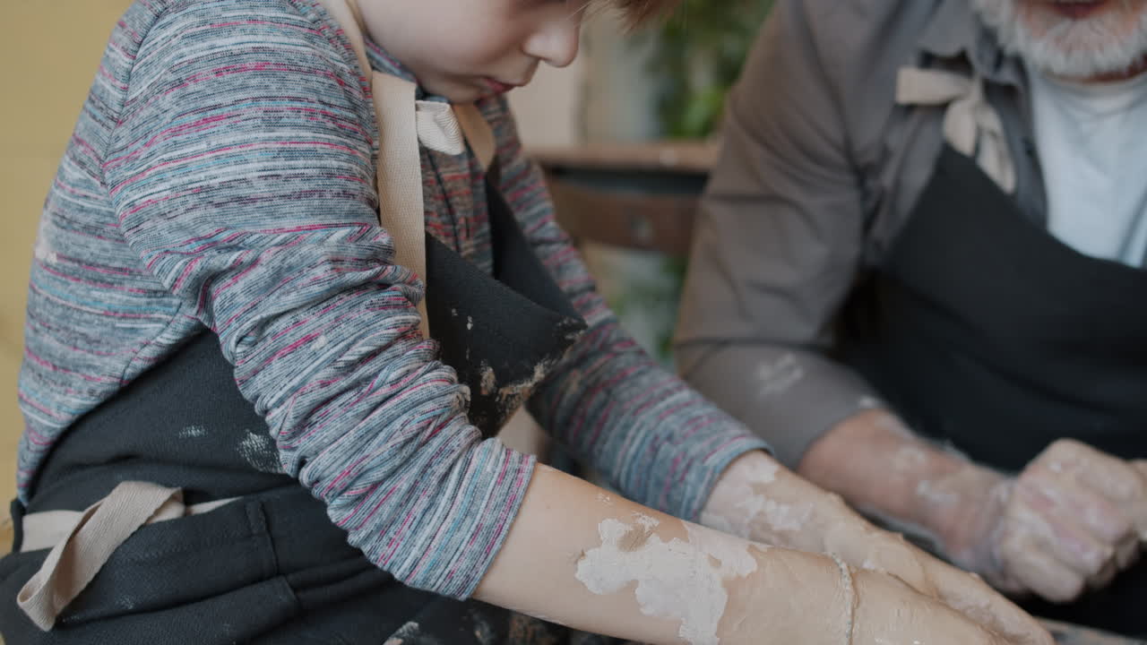 Grandfather teaching his grandchild pottery