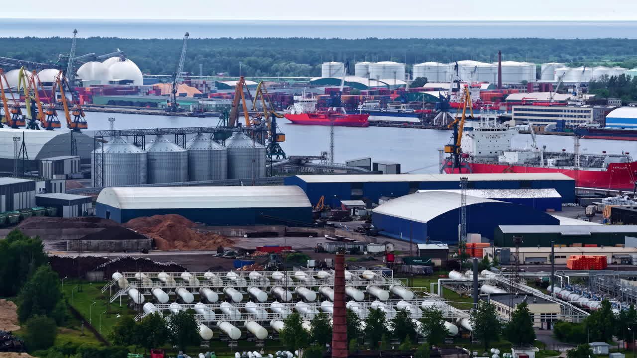 Gas storage tanks and processing infrastructure near river in port area of Latvia