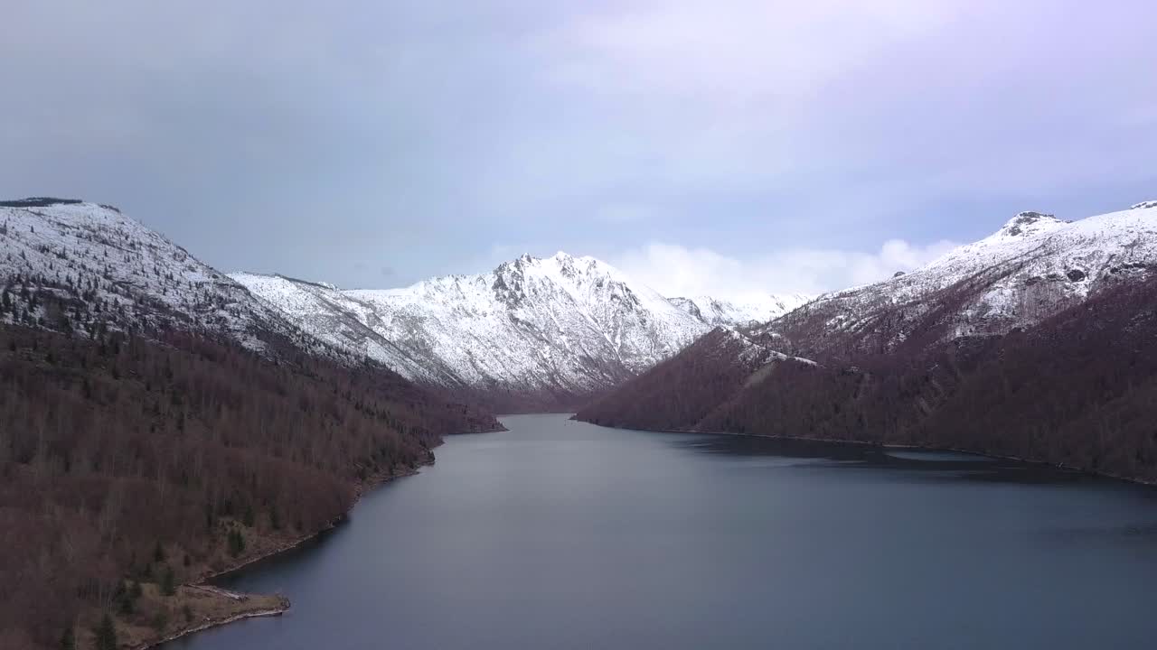 Scenic Winter Landscape: Lake Surrounded by Snow-Capped Mountains