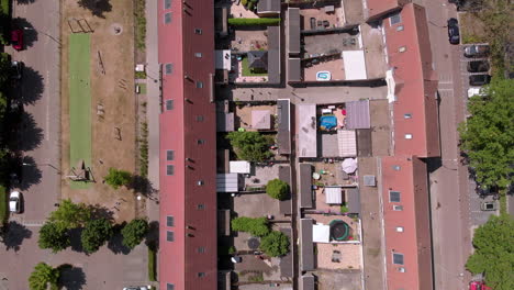 vista aérea de pájaros desde arriba hacia abajo de un barrio holandés con dos hileras de casas adosadas y jardines adyacentes y un parque infantil