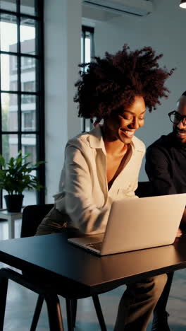 two professionals collaborating and smiling in a modern office