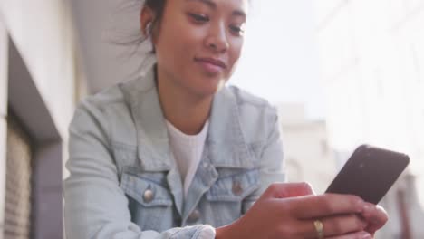 Mujer-De-Raza-Mixta-Usando-Un-Teléfono-Inteligente-En-La-Calle