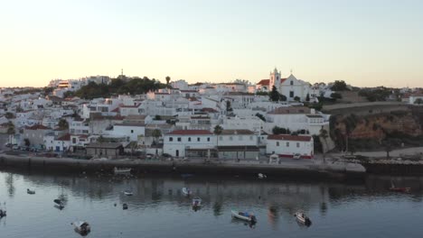 Golden-sunlight-casting-warm-light-on-houses-of-Ferragudo,-Portugal