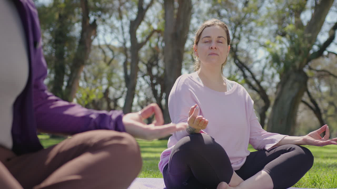 mujeres practicando yoga en un parque