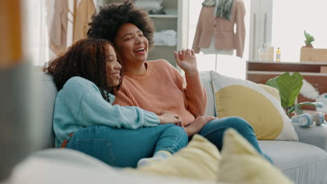 two women laughing on a couch