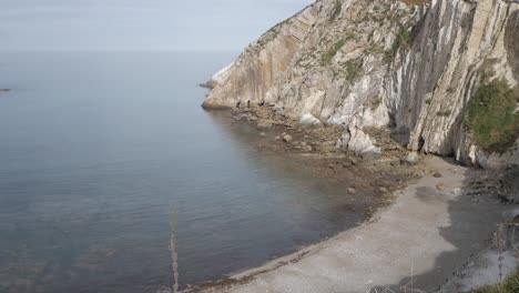 rocky beach cove at silence beach, asturias, with calm sea and steep coastal cliffs