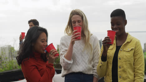 group of friends drinking a beer on a rooftop