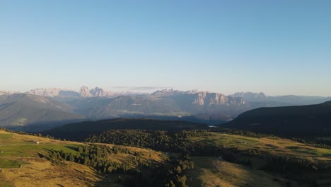 Toma-Aérea-De-Drones-De-Los-Alpes-Mientras-Se-Pone-El-Sol-Con-Cabañas-Y-Tierras-De-Cultivo,-Hermosa-Naturaleza