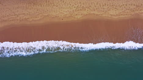 forceful ocean waves breaking on tropical sandy beach in thailand