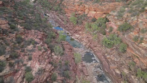 Drone-aerial-going-through-an-Australian-gorge-and-national-park-with-a-river-flowing