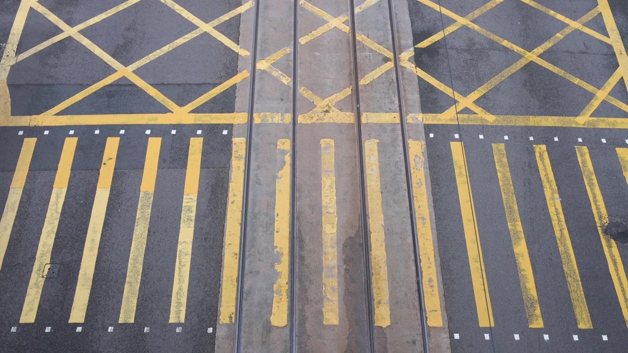 Overhead shot of a yellow-painted zebra crossing at an intersection in Hong Kong.
