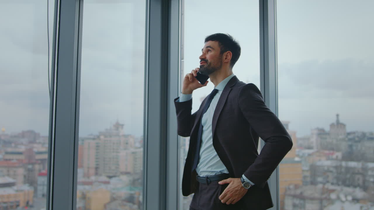hombre de negocios hablando por teléfono negociaciones de pie en la ventana de la oficina. llamada de negocios