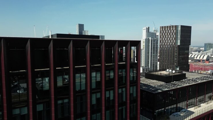 Voo de drone aéreo sobre os telhados da Oxford Road no centro da cidade de Manchester para revelar uma vista geral das Deansgate Towers