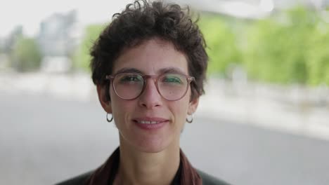 woman in eyeglasses smiling at camera outdoor