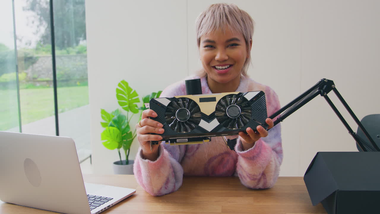 Vlogger donna con laptop e microfono in diretta streaming per una recensione di prodotti elettronici online alla telecamera