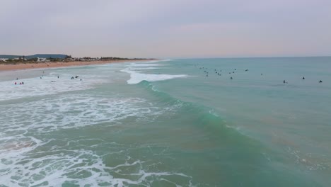 Waves-at-playa-el-palmar-beach-surf-break-with-pink-sunset-sky-in-Spain