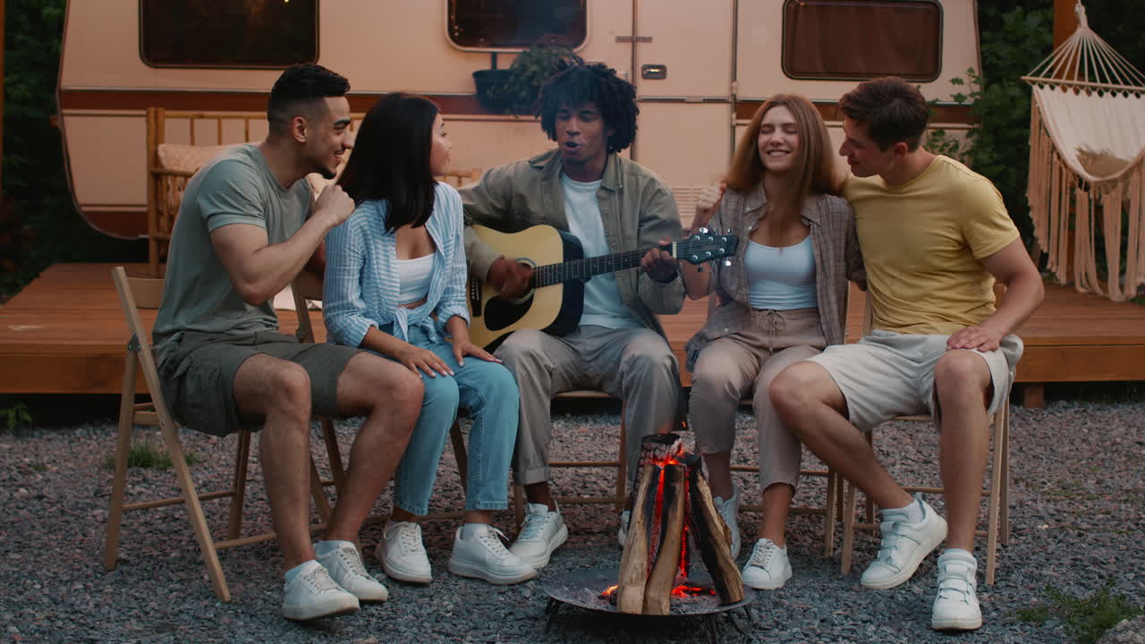 Friends Enjoying Music Around a Campfire