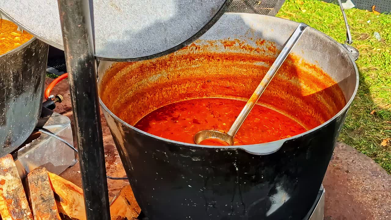 Due pentole fumanti sul fuoco, cucina all'aperto, scena rurale e rustica