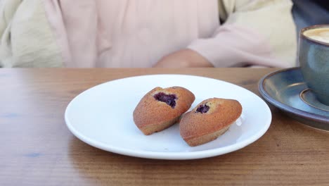 woman eating blueberry muffins with coffee