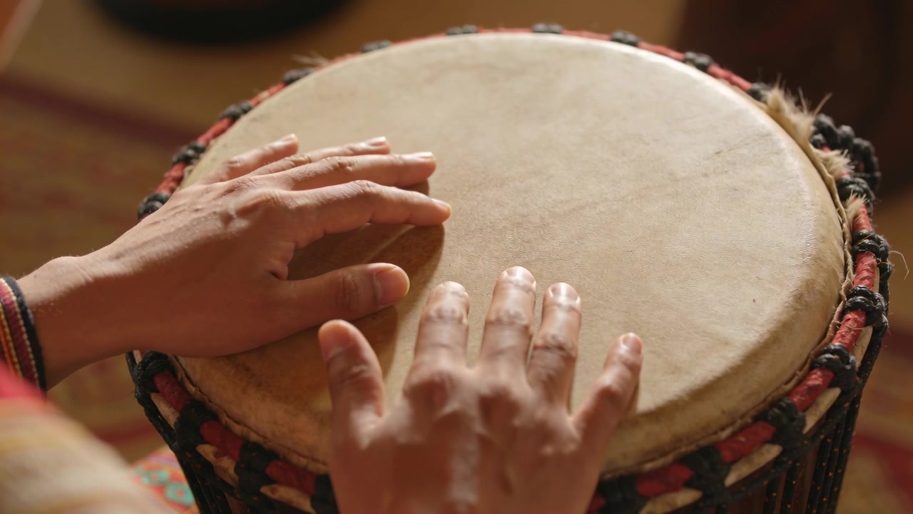 Starting from resting palms musician hands moving tapping rolling on drumhead at home woven cuff