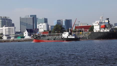 tugboats assisting a large cargo ship in a harbor