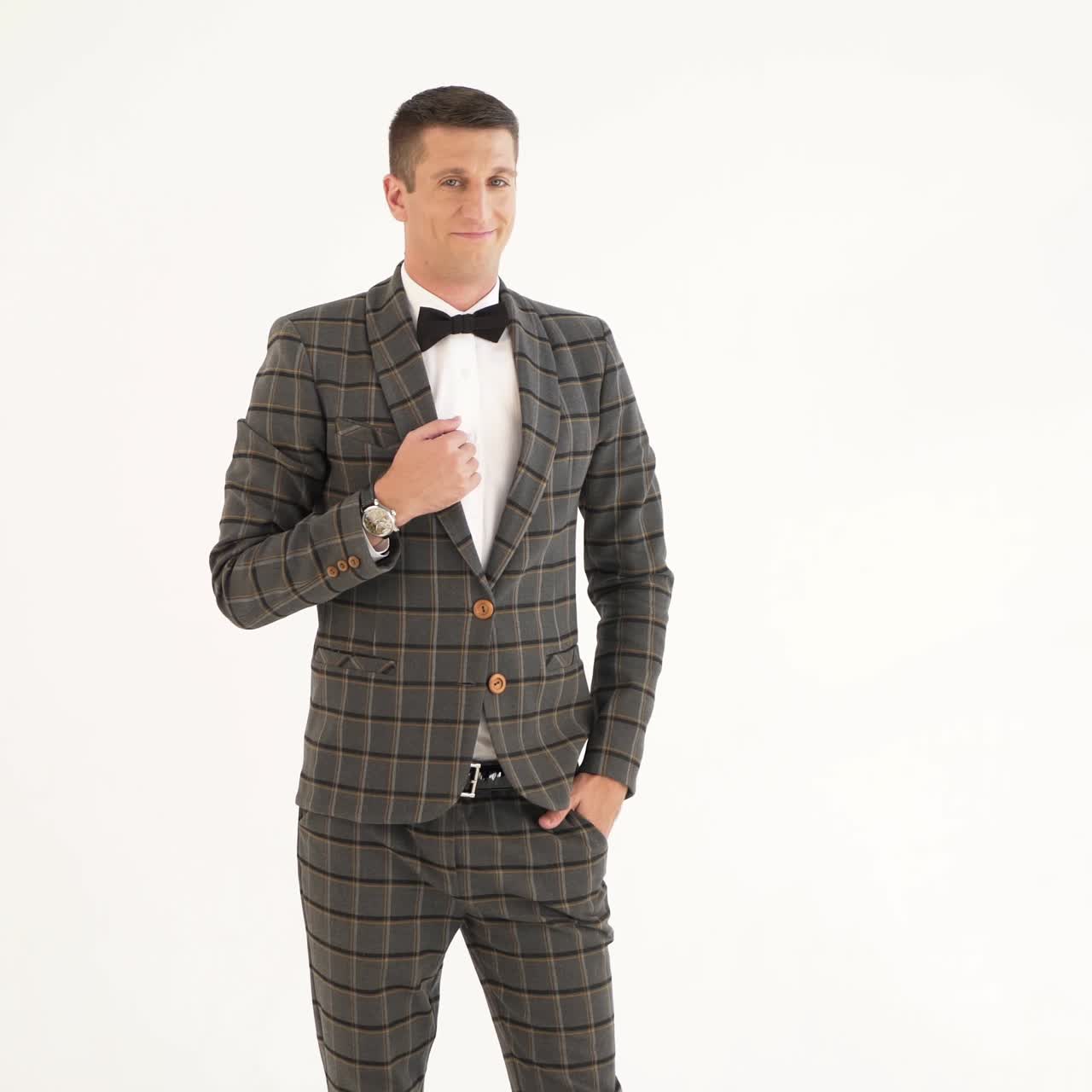 charismatic man in a plaid suit is depicting a cheerful and serious facial expression with gesticulating of hands on a white background