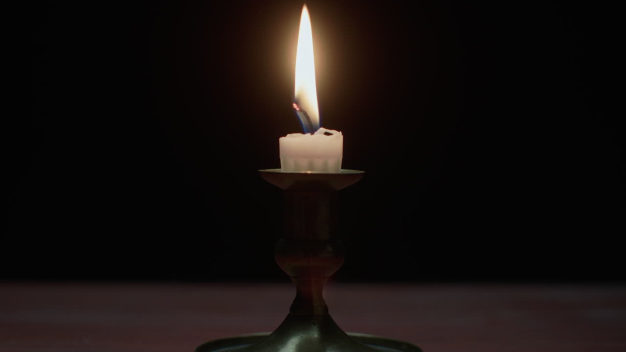 Una candela si spegne nella stanza buia