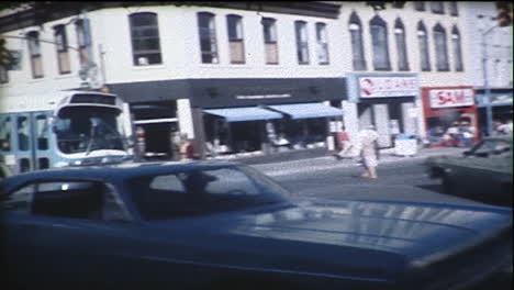 city bus makes left turns at intersection in downtown of a small city