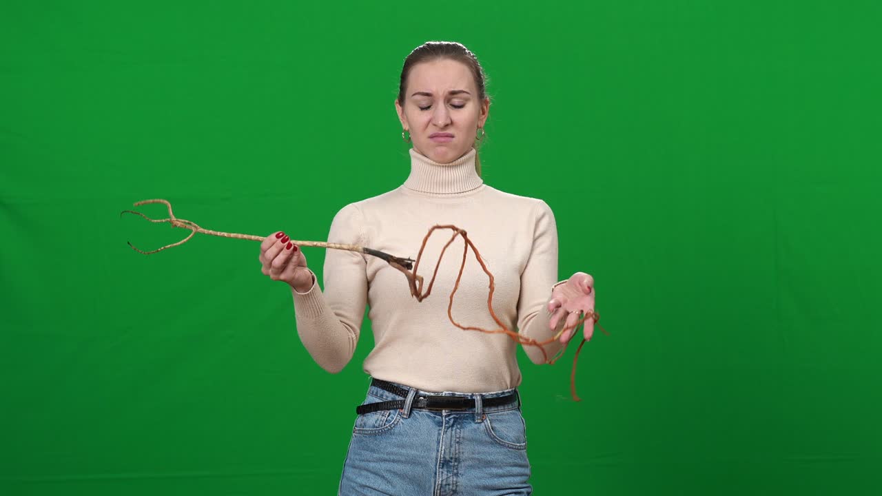 초록색 스크린에서 공연하는 은 여성의 중간 : 크로마키 배경에서 나무 뿌리와 함께 포즈를 취하는 아름다운 백인 여자의 초상화.