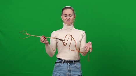 초록색 스크린에서 공연하는 은 여성의 중간 : 크로마키 배경에서 나무 뿌리와 함께 포즈를 취하는 아름다운 백인 여자의 초상화.