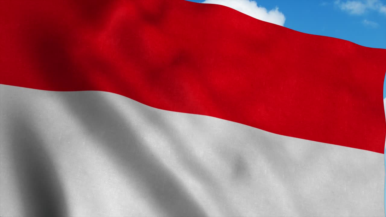 인도네시아의 국기가 바람에 흔들리고, 푸른 하늘 배경.