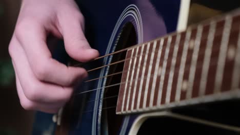 close-up of a person playing an acoustic guitar