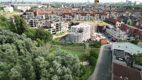 Lateral-Left-Aerial-View-of-Neighborhood-in-Ghent-Surrounded-by-Tall-Buildings-and-people-Playing-Football