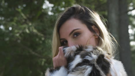 confident stylish young female model poses hiding her face behind her jacket