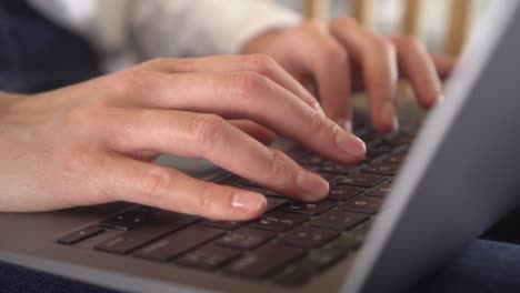 escena de primer plano de una mujer de negocios joven adulta escribiendo en una computadora portátil trabajando desde casa, hermosa mujer profesional que usa la tecnología haciendo trabajo remoto en línea en casa