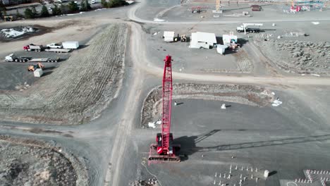 top down aerial view of a lattice boom crawler crane at a construction site, dolly zoom effect