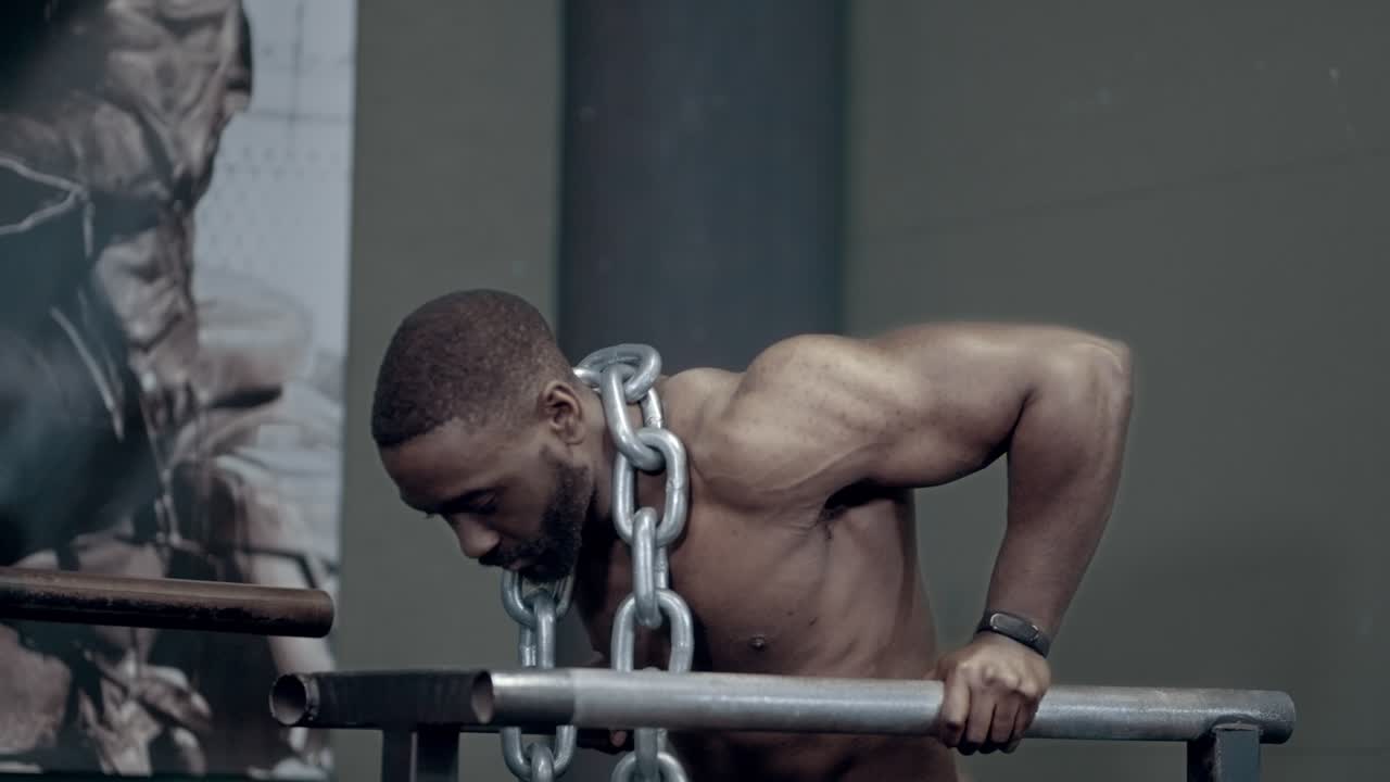 Athletic African American performing Weighted Dips