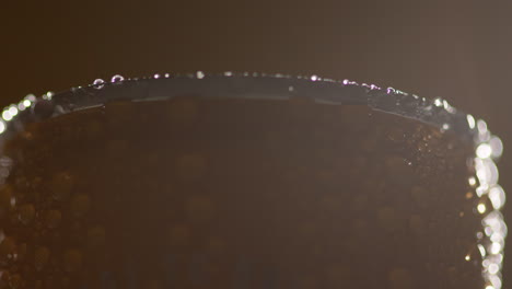 close up backlit shot of condensation droplets on revolving takeaway can of cold beer or soft drink 2