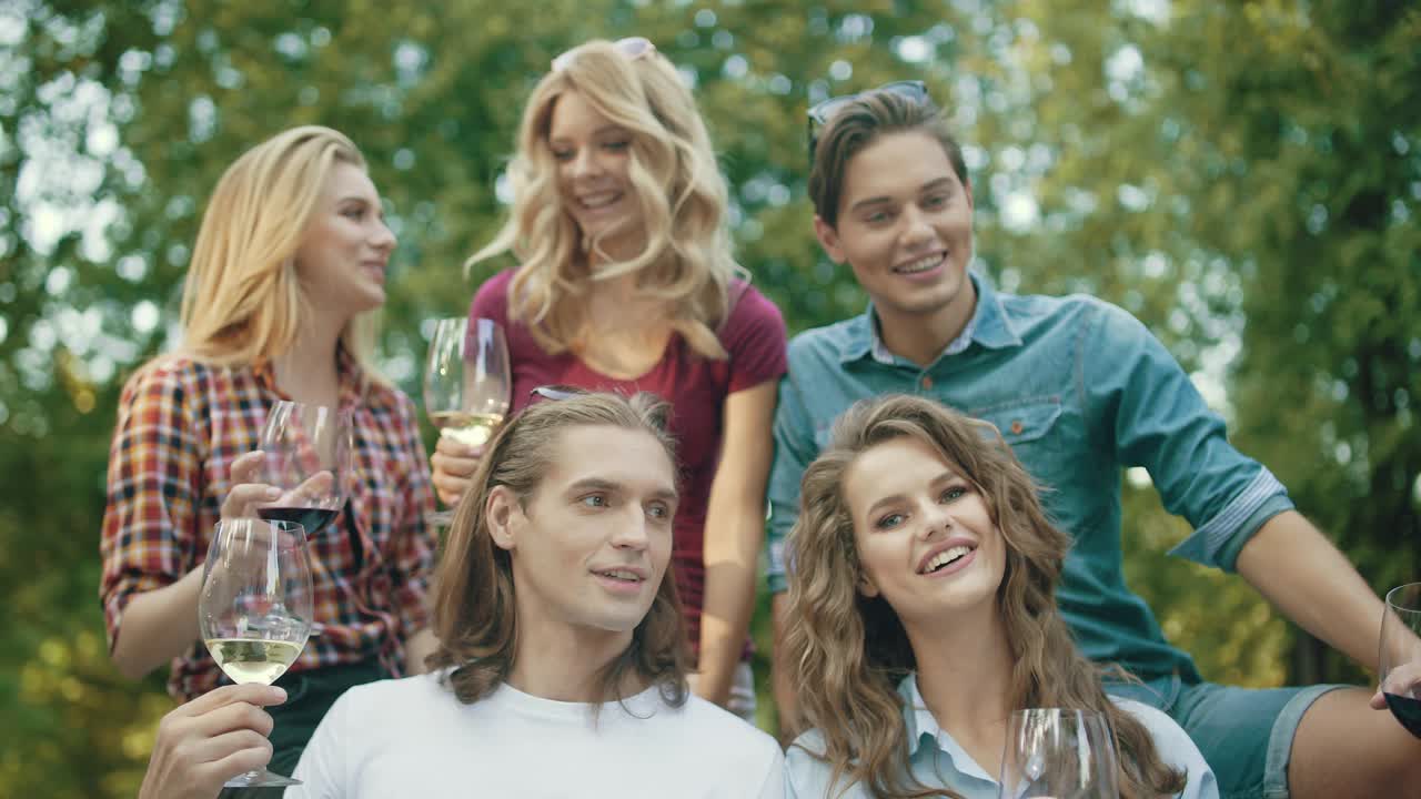 друзья поднимают тост с напитками на вечеринке на открытом воздухе