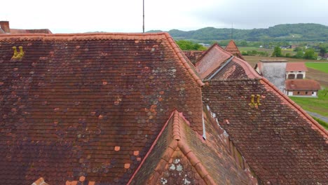 kalsdorf castle in neudorf bei ilz austria with old red and black tiled roof, drone rise to reveal