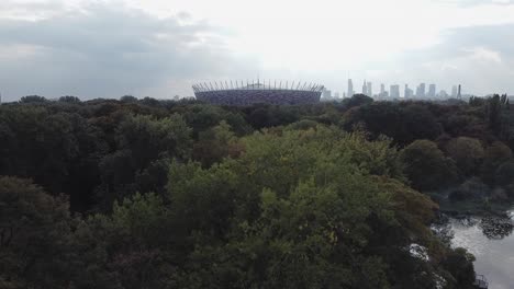 establecimiento de una toma de drones del estadio de varsovia con el horizonte de la ciudad y el bosque en el fondo