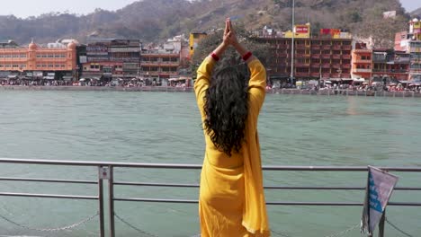 isolated young girl prying the holy ganges river at river bank from flat angle video is taken at ganga river bank haridwar uttrakhand india