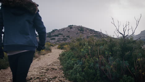 wanderer on trail through mediterranean scrubland, provence, france