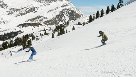 Cinematic-downhill-skiing-show-of-a-couple-on-a-steep-ski-slope-in-beautiful-mountain-landscape