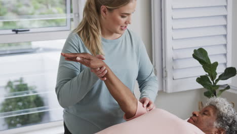 Fisioterapeuta-Femenina-Caucásica-Masajeando-A-Una-Mujer-Mayor,-Espacio-Para-Copiar,-Cámara-Lenta