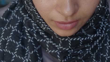 a woman in a hijab drinks coffee