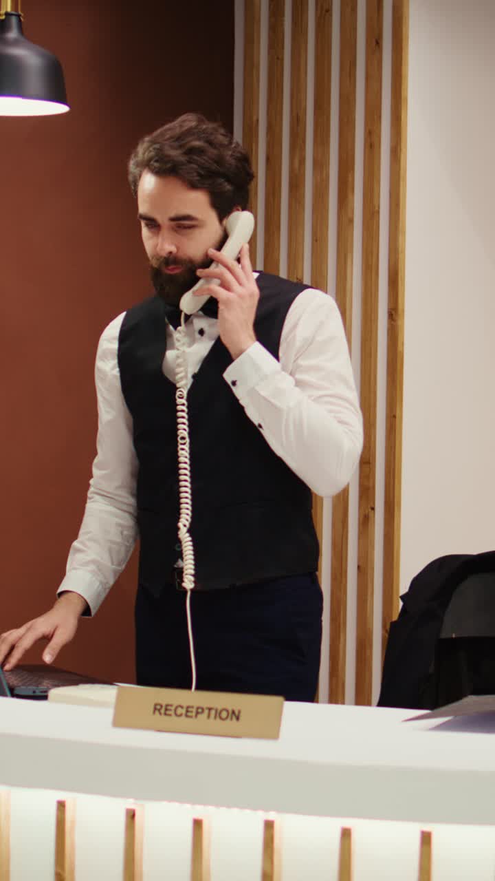 Addetta alla reception di un hotel al telefono alla reception