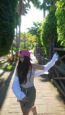 adolescente bailando en un parque tropical