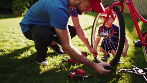 father and son fixing a bicycle in the garden