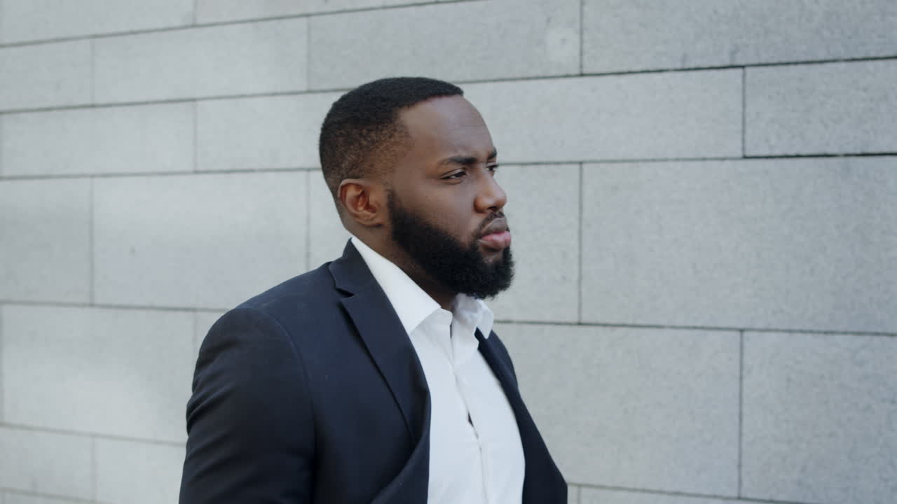 African businessman walking on street. Male professional going fo work outdoors
